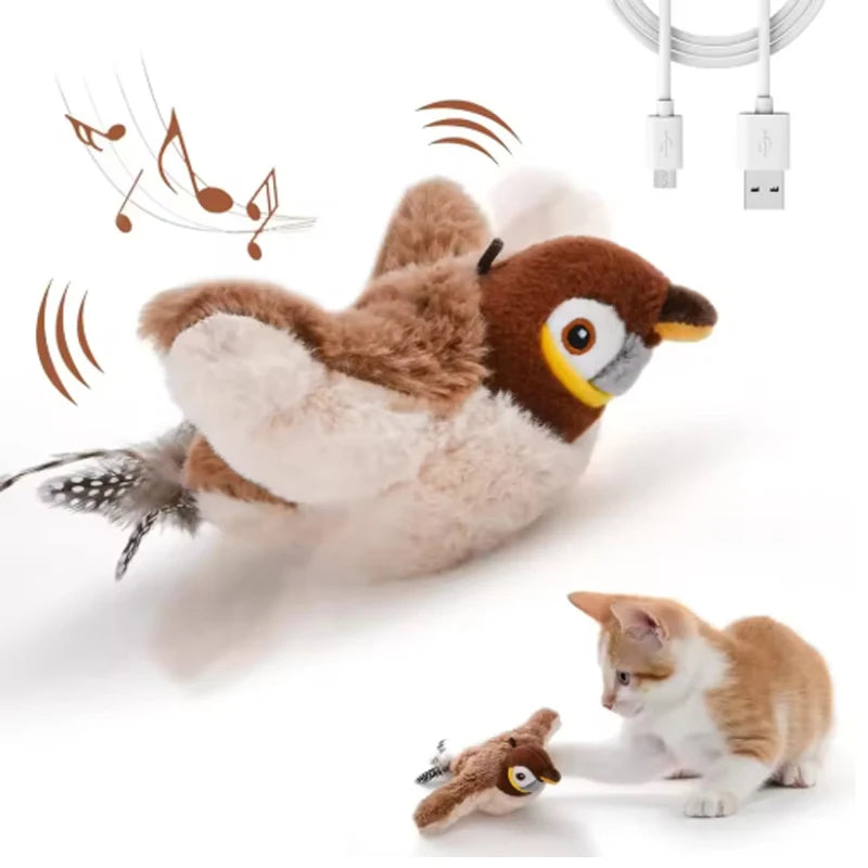 Brown plush sparrow with its USB cable, and a kitten pawing it in the corner