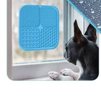 Cat licking a lick mat stuck to a window